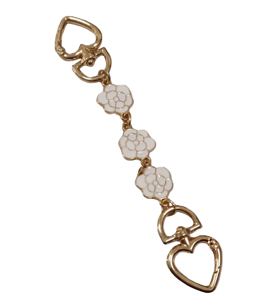 Gold and white floral keychain on a white background