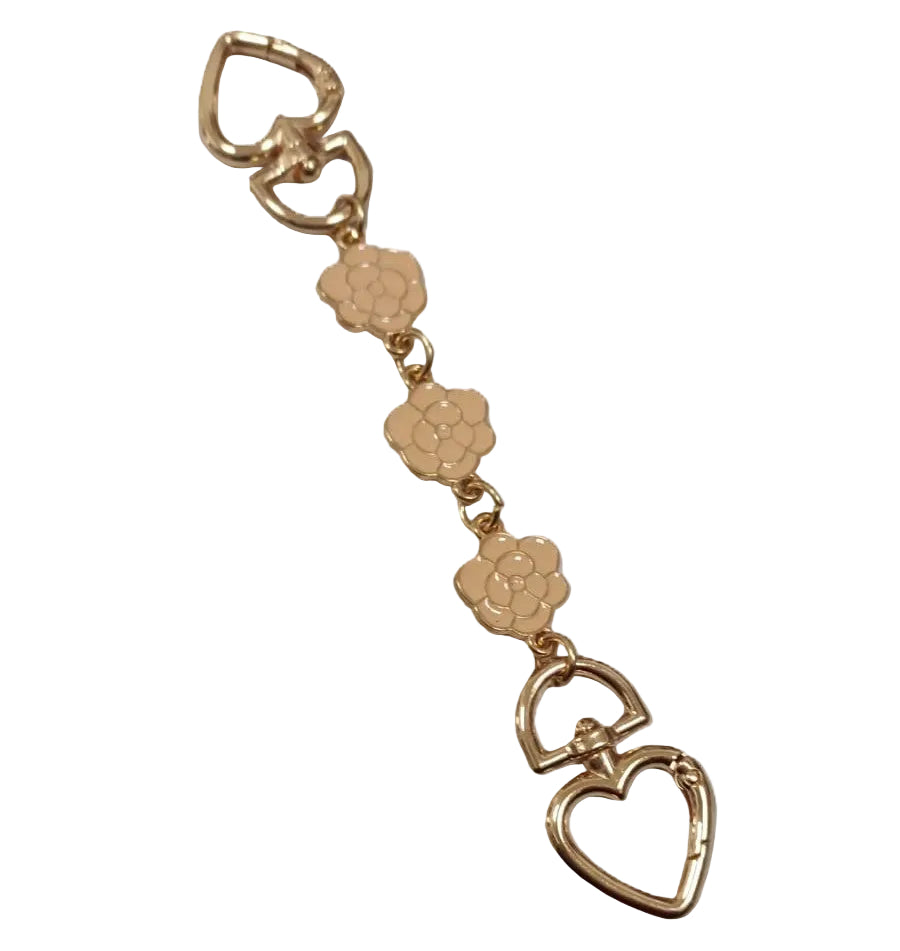 Gold keychain with floral and heart designs on a white background