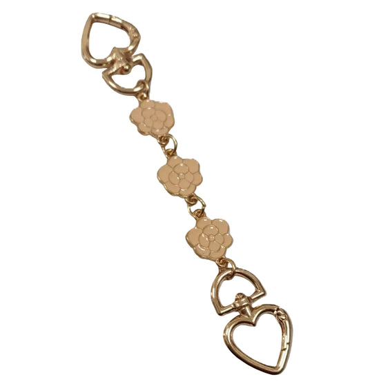 Gold keychain with floral and heart designs on a white background